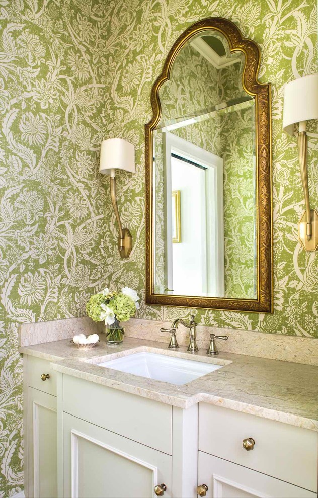 This is an example of a traditional powder room in Atlanta with recessed-panel cabinets, green walls, an undermount sink, white cabinets and beige benchtops.