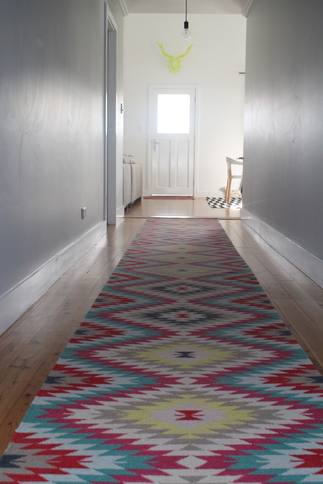 Photo of an eclectic hallway in Sydney with grey walls and light hardwood floors.