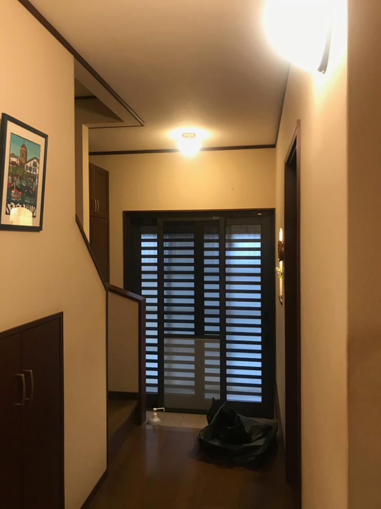 Foto di un corridoio eclettico di medie dimensioni con pareti beige, pavimento in gres porcellanato, una porta scorrevole, una porta nera, pavimento nero, soffitto in carta da parati e carta da parati