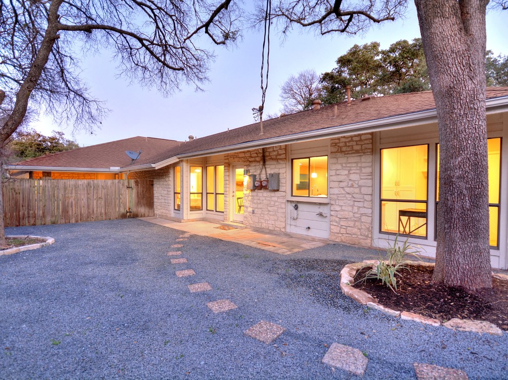 Home design - mid-sized transitional one-story stone white home design idea in Austin with a shed roof
