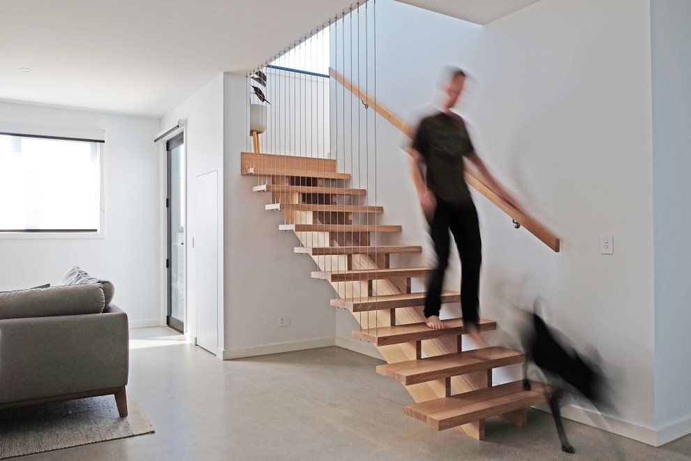 Cette photo montre un petit escalier sans contremarche droit scandinave avec des marches en bois et un garde-corps en métal.