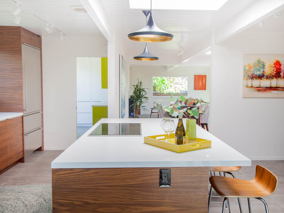 This is an example of a mid-sized midcentury galley open plan kitchen in San Francisco with an undermount sink, flat-panel cabinets, medium wood cabinets, quartz benchtops, multi-coloured splashback, ceramic splashback, stainless steel appliances, ceramic floors, with island and grey floor.