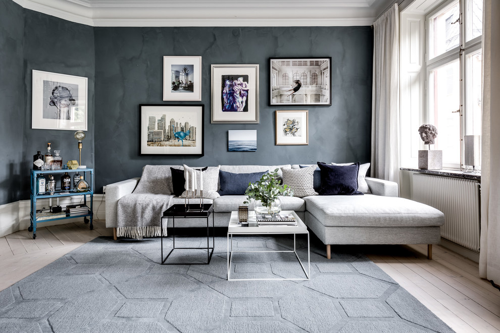 Inspiration for a large scandinavian formal open concept living room in Stockholm with black walls, light hardwood floors and white floor.