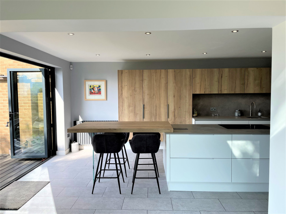 Medium sized contemporary l-shaped kitchen/diner in Other with a single-bowl sink, flat-panel cabinets, white cabinets, composite countertops, grey splashback, vinyl flooring, an island, grey floors and grey worktops.