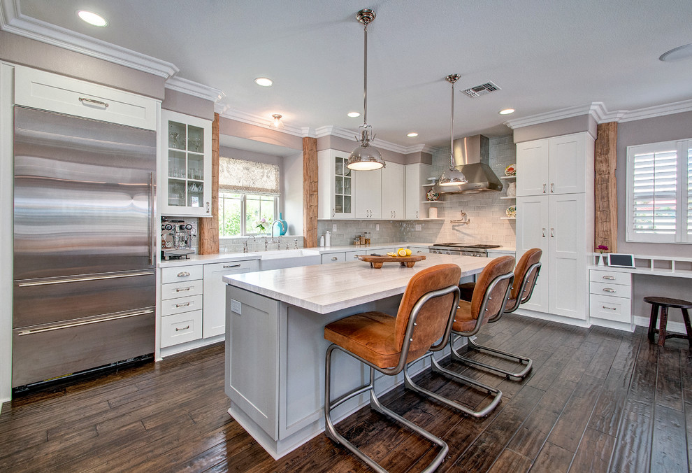 Mid-sized transitional l-shaped dark wood floor eat-in kitchen photo in San Diego with a farmhouse sink, shaker cabinets, white cabinets, marble countertops, blue backsplash, ceramic backsplash, stainless steel appliances and an island