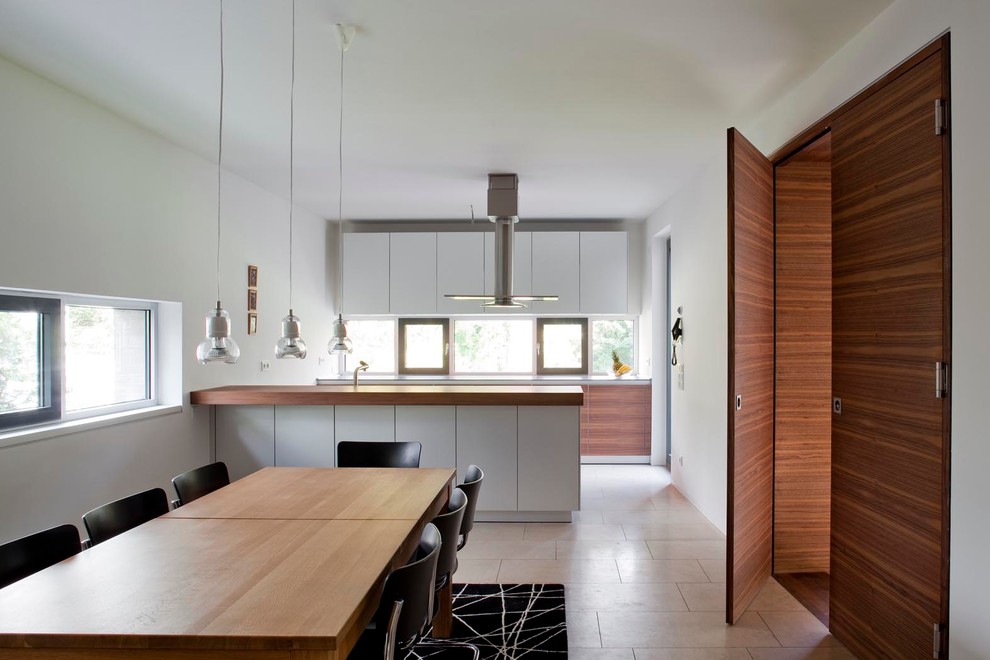 Large contemporary eat-in kitchen in Berlin with flat-panel cabinets, grey cabinets, glass sheet splashback and a peninsula.