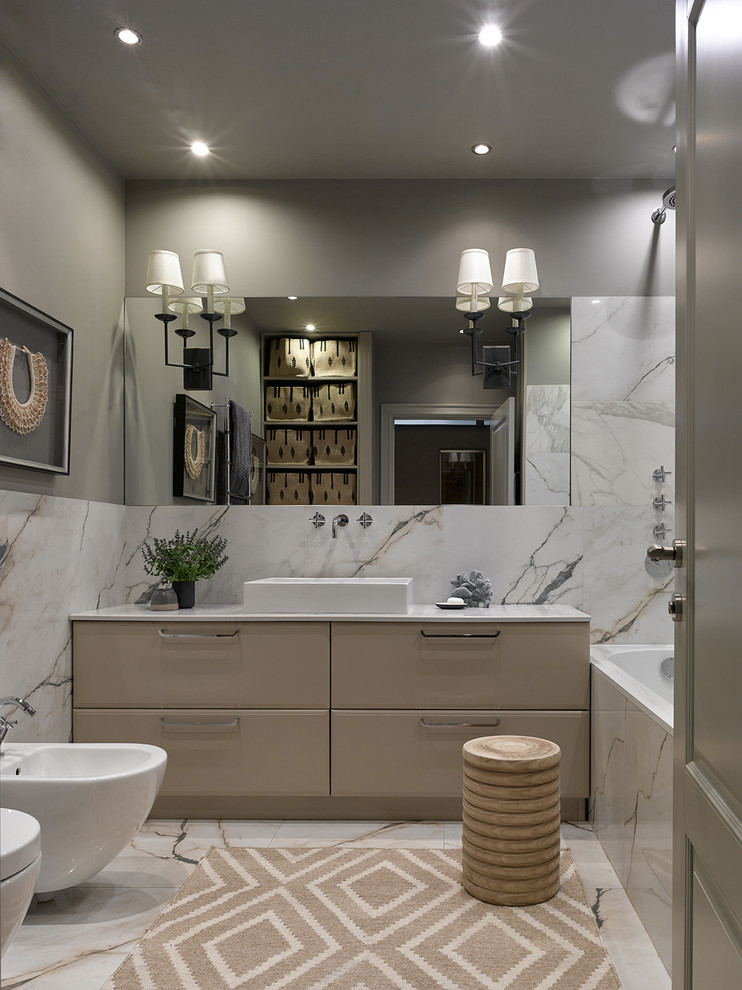 This is an example of a mid-sized transitional master bathroom in Moscow with beige cabinets, an alcove tub, white tile, porcelain tile, grey walls, porcelain floors, white floor, flat-panel cabinets, a bidet and a vessel sink.