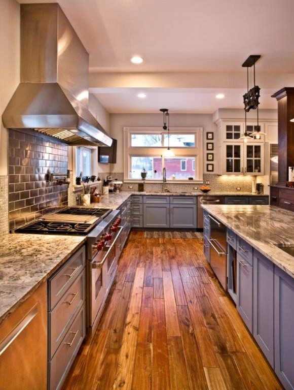 Inspiration for a large arts and crafts u-shaped open plan kitchen in Minneapolis with an undermount sink, shaker cabinets, blue cabinets, copper benchtops, metallic splashback, metal splashback, stainless steel appliances, medium hardwood floors, with island and brown floor.