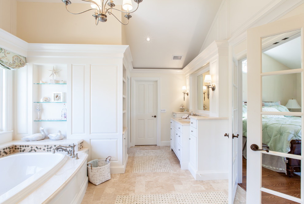 Inspiration for an expansive traditional master bathroom in San Diego with furniture-like cabinets, white cabinets, a drop-in tub, a double shower, a one-piece toilet, beige tile, travertine, beige walls, travertine floors, an undermount sink and marble benchtops.