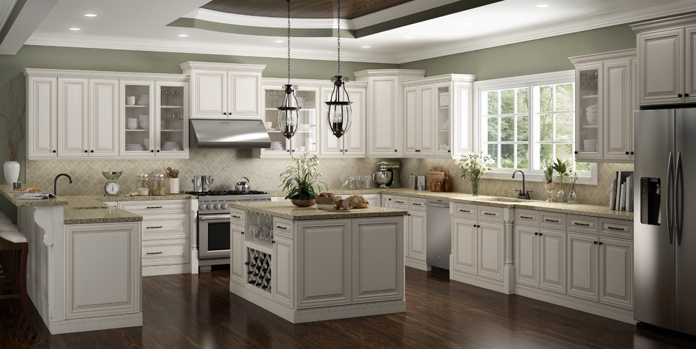 Inspiration for a large traditional u-shaped kitchen in Los Angeles with an undermount sink, raised-panel cabinets, white cabinets, solid surface benchtops, beige splashback, stone tile splashback, stainless steel appliances, dark hardwood floors and with island.