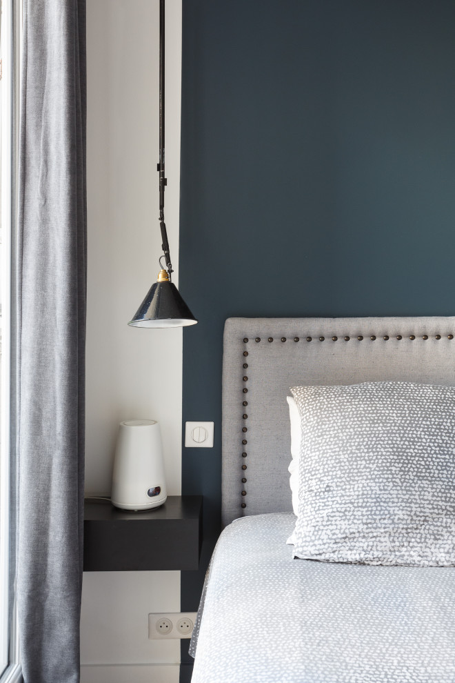 Réalisation d'une chambre parentale minimaliste de taille moyenne avec un mur bleu, parquet clair, aucune cheminée et un sol beige.