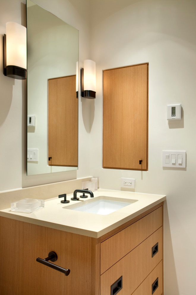 Cette image montre une salle de bain principale design en bois brun de taille moyenne avec un placard à porte plane, un espace douche bain, un mur blanc, un lavabo encastré, un plan de toilette en quartz modifié, aucune cabine, un plan de toilette beige, meuble simple vasque et meuble-lavabo encastré.
