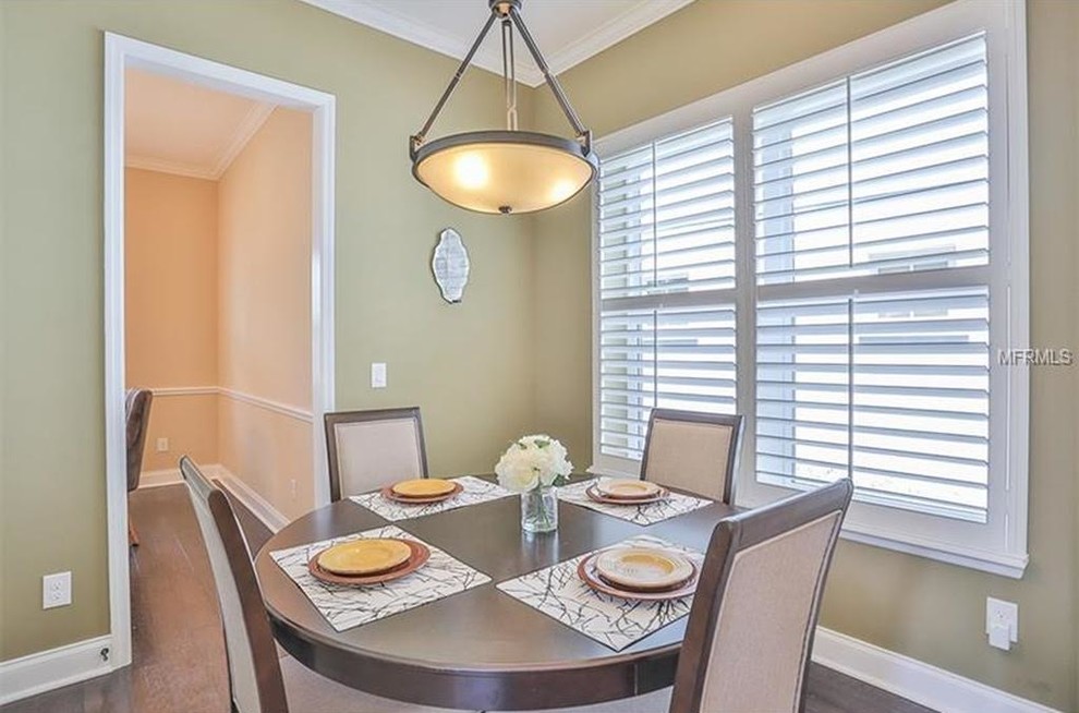 Example of a mid-sized transitional dark wood floor and brown floor enclosed dining room design in Orlando with beige walls
