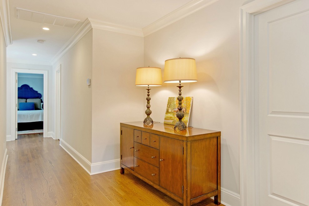Large transitional hallway in New York with white walls and light hardwood floors.
