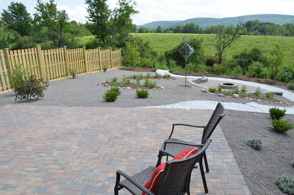 Inspiration for a mid-sized transitional backyard patio in New York with brick pavers, no cover and a fire feature.