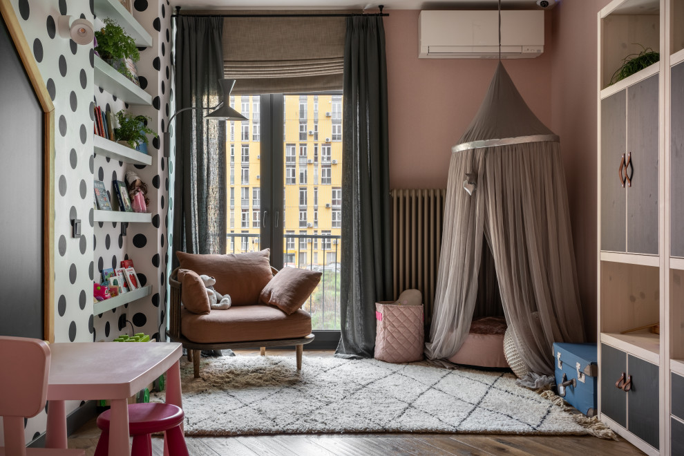 This is an example of a large contemporary kids' playroom for kids 4-10 years old and girls in Other with pink walls, medium hardwood floors, brown floor and wallpaper.