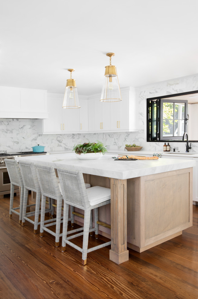 Design ideas for a large beach style l-shaped kitchen in Charleston with an undermount sink, recessed-panel cabinets, white cabinets, grey splashback, stainless steel appliances, medium hardwood floors, with island, brown floor and white benchtop.