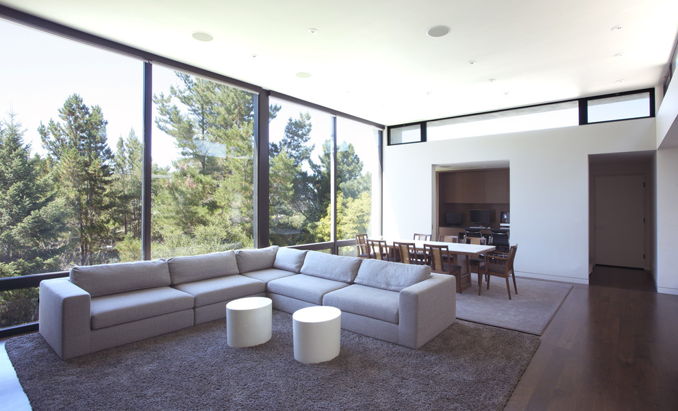 This is an example of a modern open concept living room in San Francisco with white walls and dark hardwood floors.