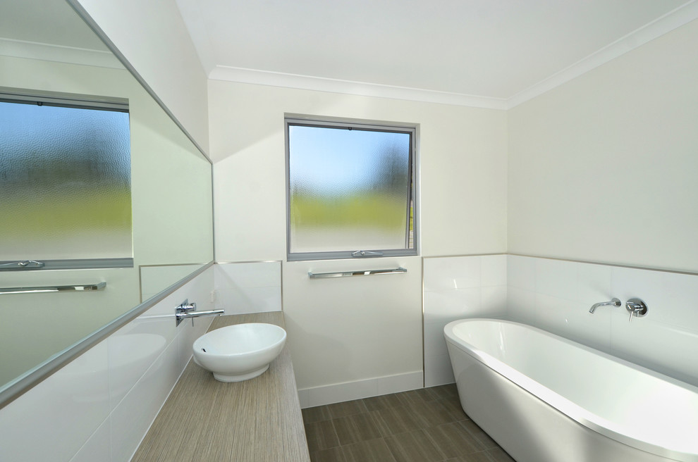 Contemporary bathroom in Perth with a vessel sink, beige cabinets, laminate benchtops, a freestanding tub, ceramic tile, white walls and ceramic floors.