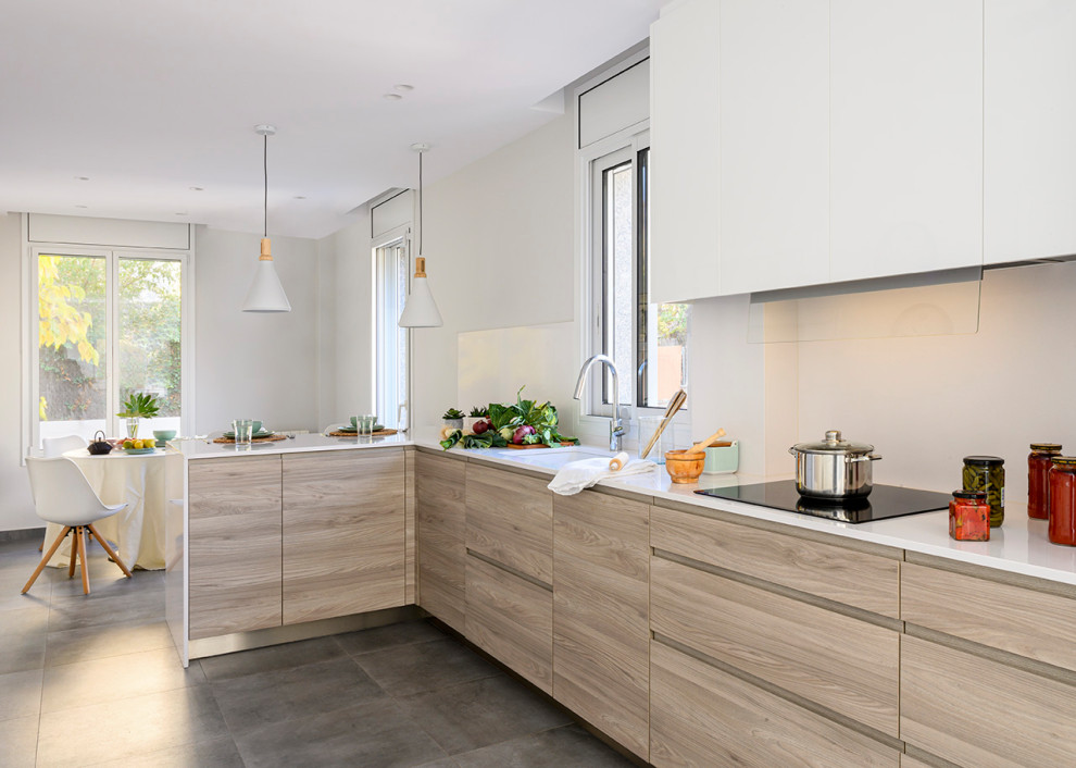 This is an example of a mid-sized contemporary l-shaped eat-in kitchen in Other with an undermount sink, flat-panel cabinets, quartzite benchtops, white splashback, limestone splashback, stainless steel appliances, ceramic floors, a peninsula, grey floor, white benchtop, recessed and light wood cabinets.