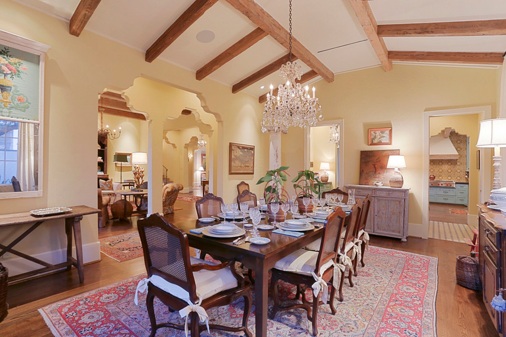 Large mediterranean separate dining room in Houston with yellow walls and medium hardwood floors.