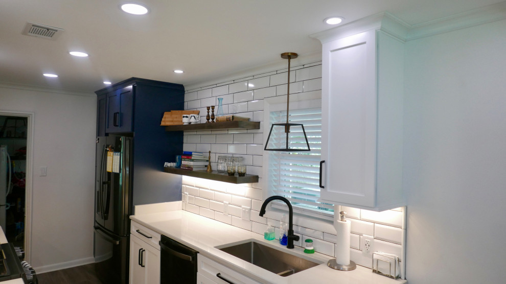 Inspiration for a mid-sized transitional galley porcelain tile and gray floor eat-in kitchen remodel with an undermount sink, shaker cabinets, white cabinets, quartz countertops, white backsplash, subway tile backsplash, black appliances, no island and white countertops