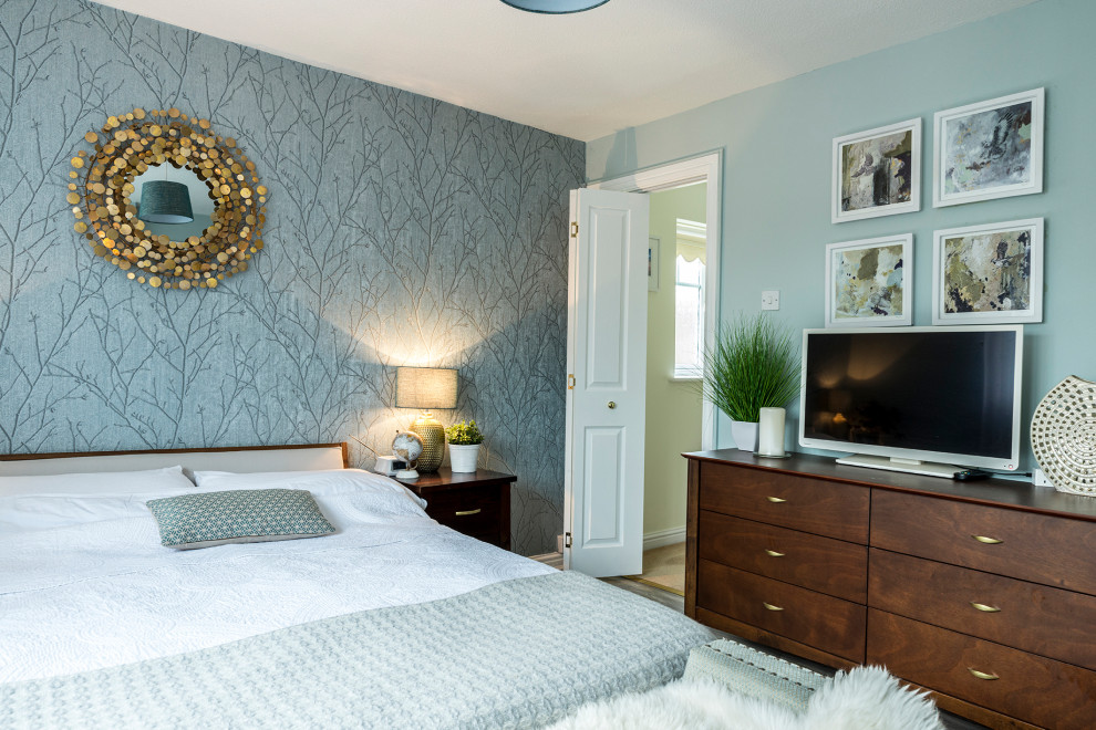 Photo of a mid-sized contemporary guest bedroom in Other with green walls, laminate floors and wallpaper.