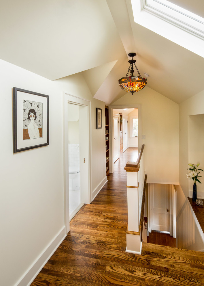 Photo of a mid-sized arts and crafts hallway in Orange County with white walls, medium hardwood floors and brown floor.