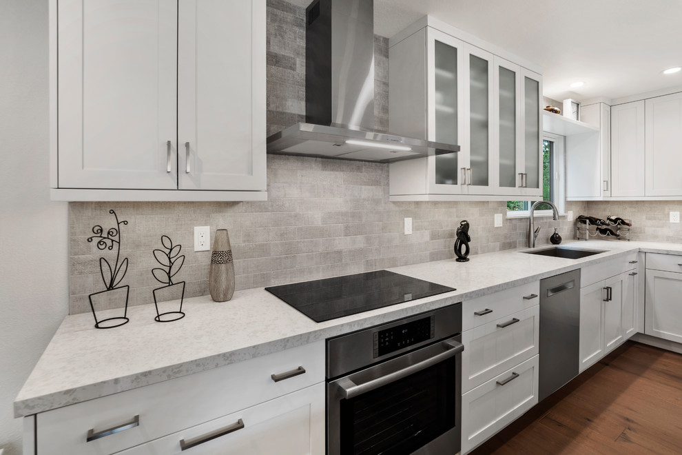 Kitchen pantry - mid-sized transitional l-shaped medium tone wood floor and brown floor kitchen pantry idea with an undermount sink, shaker cabinets, white cabinets, quartz countertops, beige backsplash, subway tile backsplash, stainless steel appliances, an island and beige countertops