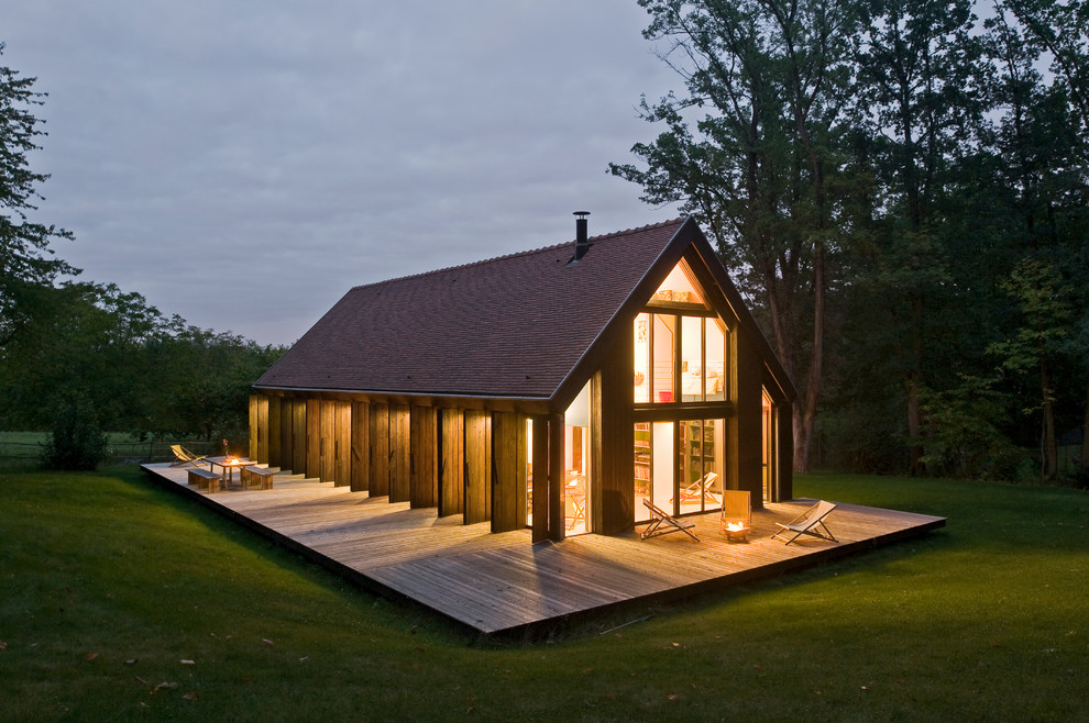 This is an example of a mid-sized contemporary two-storey exterior in Paris with a gable roof and wood siding.