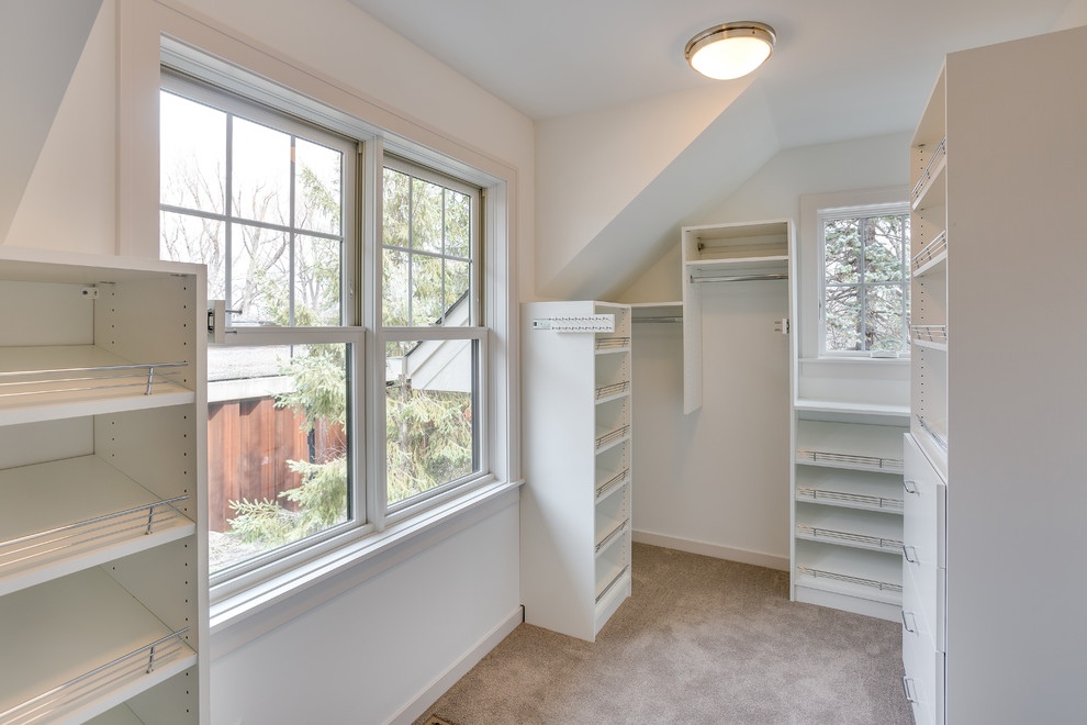 Design ideas for a mid-sized arts and crafts gender-neutral walk-in wardrobe in Minneapolis with open cabinets, white cabinets and carpet.