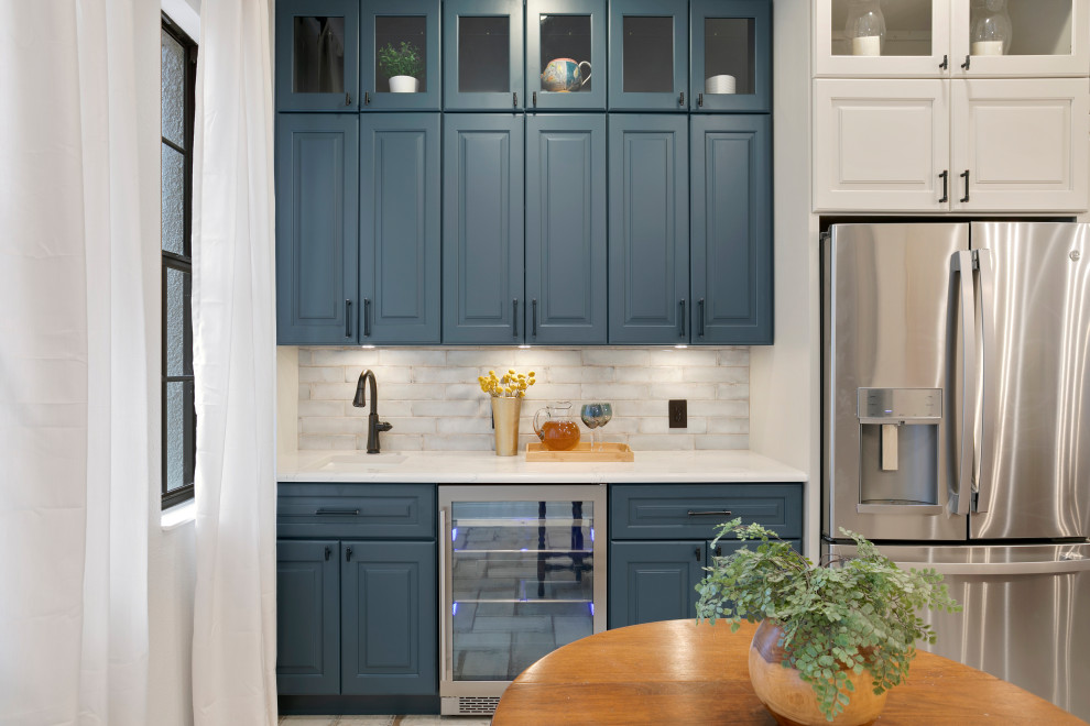 This is an example of a mid-sized contemporary l-shaped home bar in Tampa with an undermount sink, shaker cabinets, blue cabinets, quartz benchtops, white splashback, stone tile splashback and beige floor.