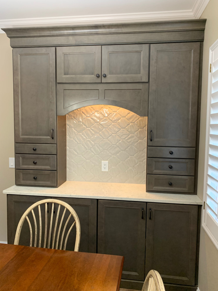 Example of a mid-sized transitional l-shaped medium tone wood floor and brown floor eat-in kitchen design in Cincinnati with an undermount sink, recessed-panel cabinets, gray cabinets, quartz countertops, white backsplash, porcelain backsplash, stainless steel appliances, an island and white countertops