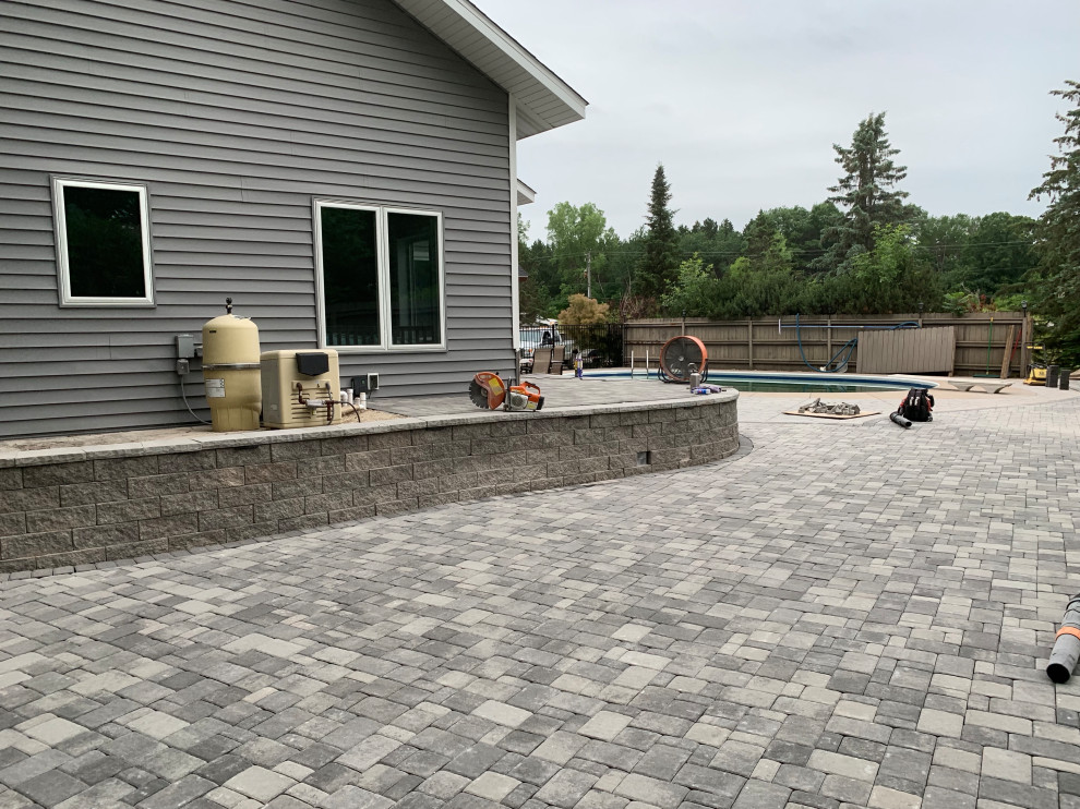 Large traditional front yard patio in Minneapolis with concrete pavers.