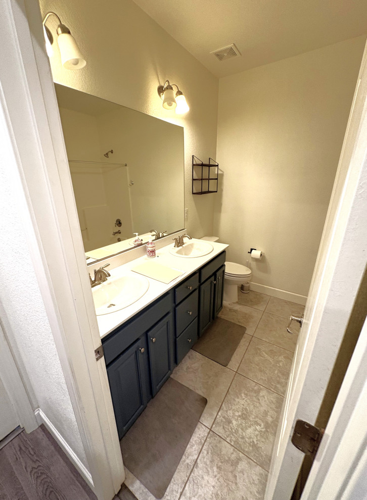 Mid-sized transitional green tile and porcelain tile vinyl floor, gray floor and double-sink alcove bathtub photo with shaker cabinets, green cabinets, an undermount sink, solid surface countertops, white countertops and a built-in vanity