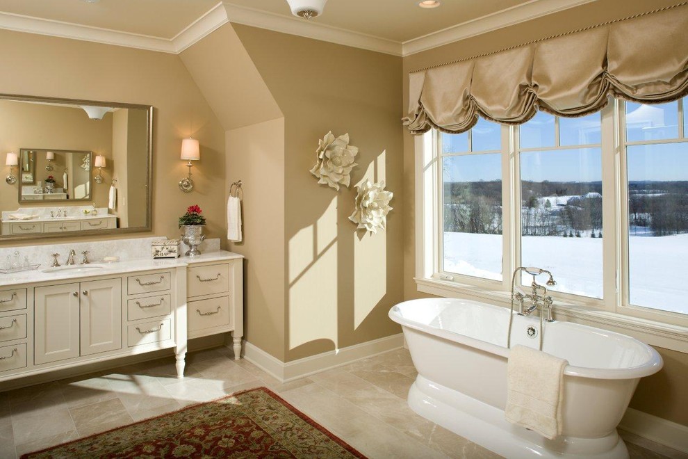 This is an example of a traditional bathroom in Minneapolis with a freestanding tub and marble benchtops.