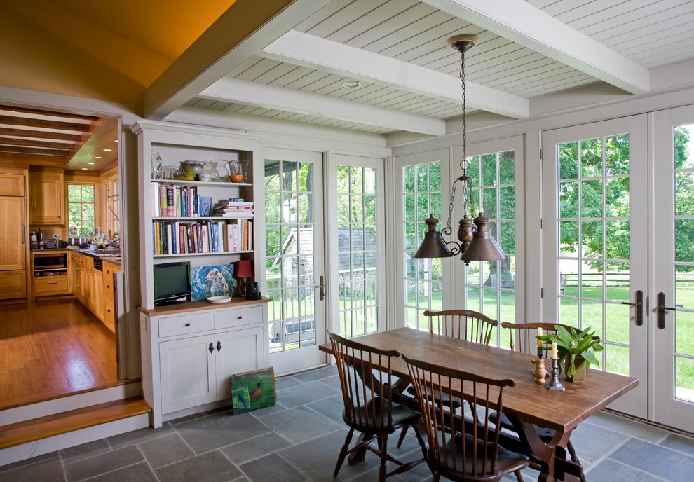 This is an example of a traditional dining room in Philadelphia with white walls and slate floors.