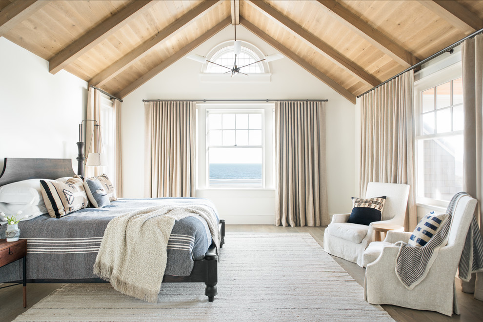 Beach style bedroom in Charleston with white walls, medium hardwood floors, no fireplace and brown floor.