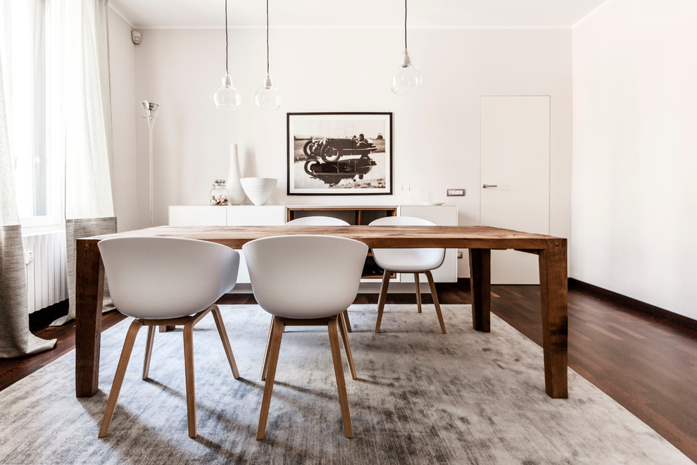 Design ideas for a large modern dining room in Milan with white walls and dark hardwood floors.