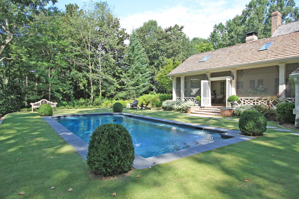Inspiration for a mid-sized traditional backyard rectangular lap pool in Atlanta with a water feature.