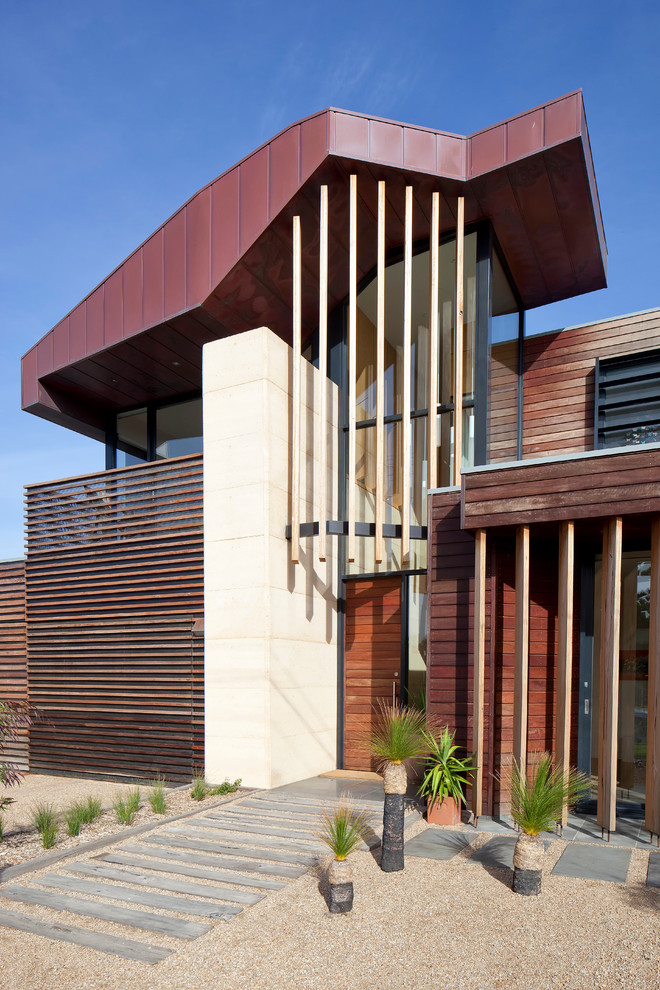 Design ideas for a contemporary two-storey brown exterior in Melbourne with wood siding.