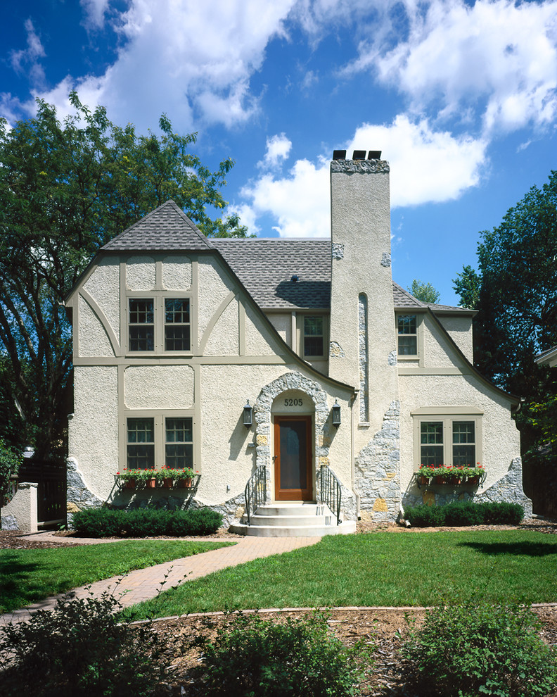 Design ideas for a large traditional two-storey stucco grey exterior in Minneapolis.