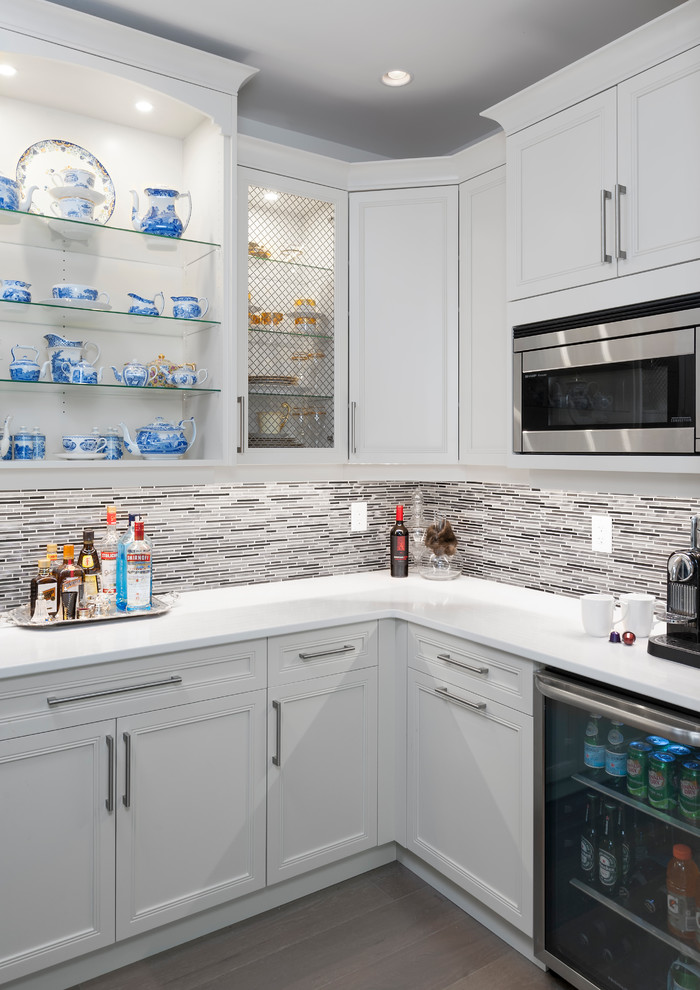 Kitchen pantry - large transitional u-shaped medium tone wood floor and brown floor kitchen pantry idea with an undermount sink, recessed-panel cabinets, quartz countertops, gray backsplash, glass tile backsplash, stainless steel appliances, an island, white countertops and white cabinets