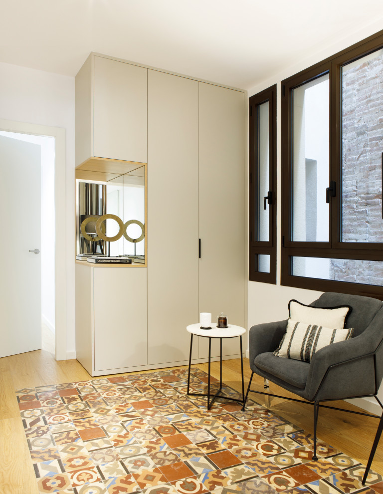Medium sized classic hallway in Barcelona with white walls, light hardwood flooring and multi-coloured floors.