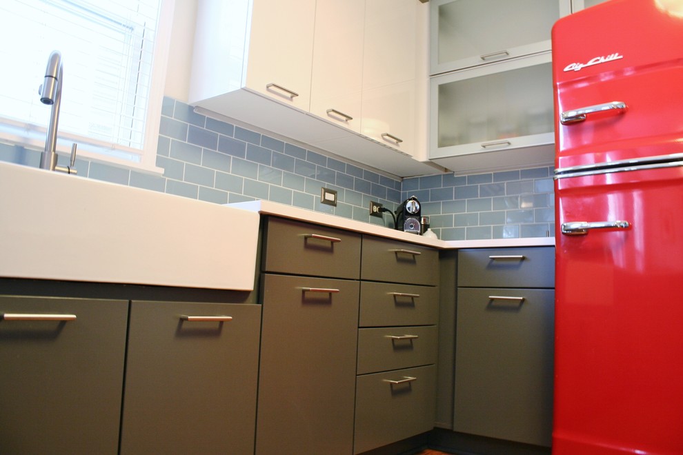 Example of a mid-sized minimalist u-shaped medium tone wood floor kitchen design with a farmhouse sink, flat-panel cabinets, gray cabinets, quartz countertops, blue backsplash, subway tile backsplash and colored appliances