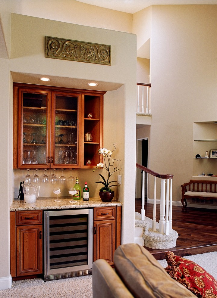 Small traditional single-wall wet bar in San Diego with glass-front cabinets, medium wood cabinets, granite benchtops and carpet.