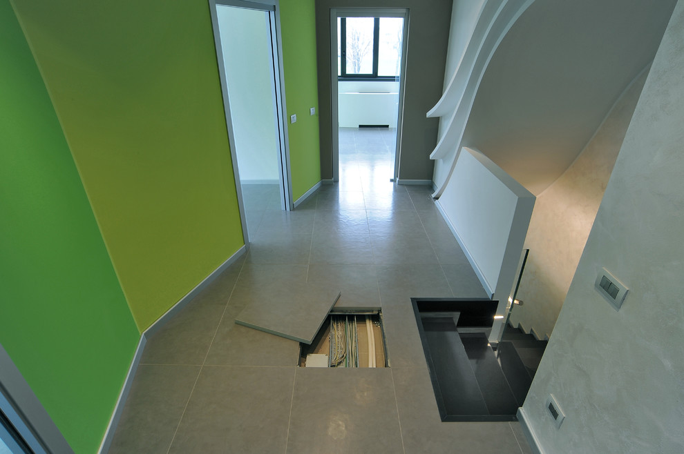 This is an example of a large industrial hallway in Milan with grey walls and porcelain floors.