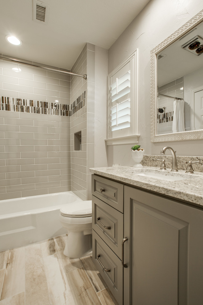 Inspiration for a mid-sized transitional 3/4 bathroom in Dallas with raised-panel cabinets, grey cabinets, an alcove tub, a shower/bathtub combo, a one-piece toilet, beige tile, ceramic tile, beige walls, an undermount sink, quartzite benchtops and a shower curtain.