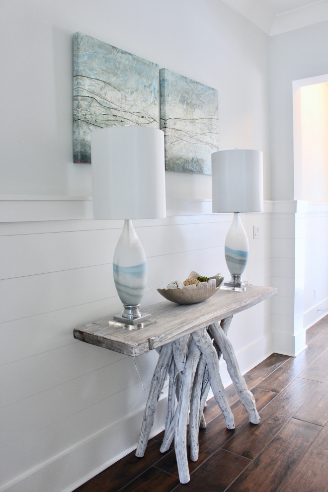 Inspiration for a mid-sized beach style entry hall in Other with white walls, medium hardwood floors and brown floor.