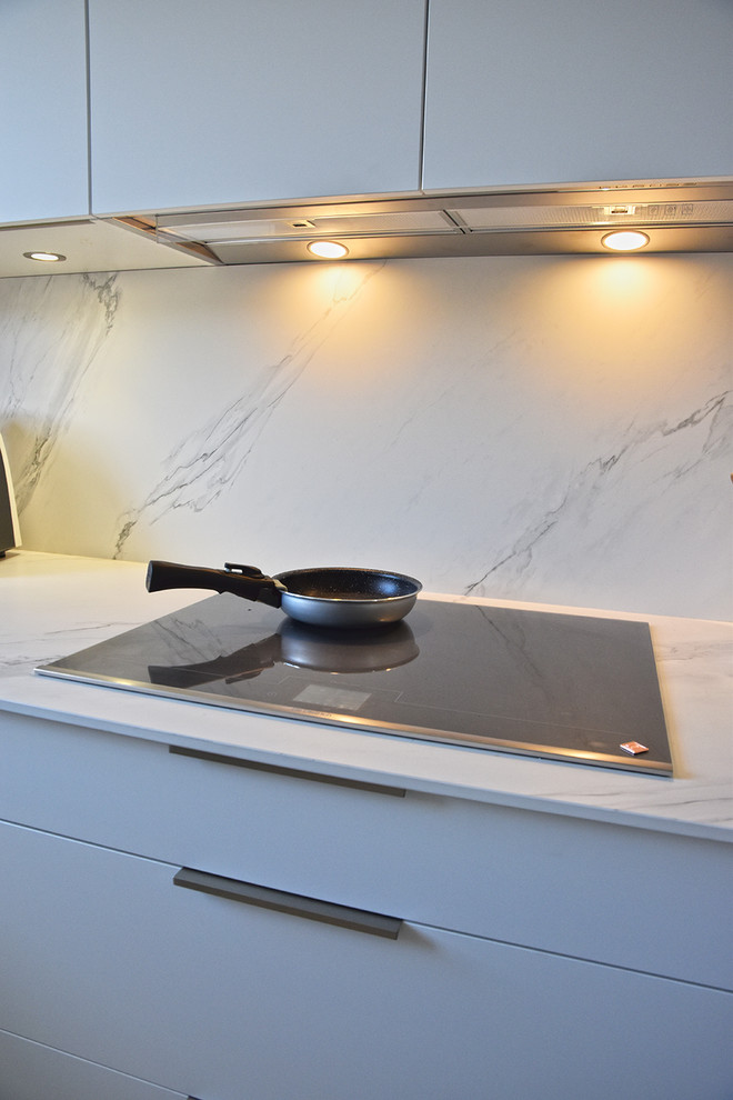 Inspiration for a mid-sized modern u-shaped separate kitchen in Lyon with an integrated sink, beaded inset cabinets, white cabinets, tile benchtops, white splashback, ceramic splashback, stainless steel appliances, ceramic floors and grey floor.